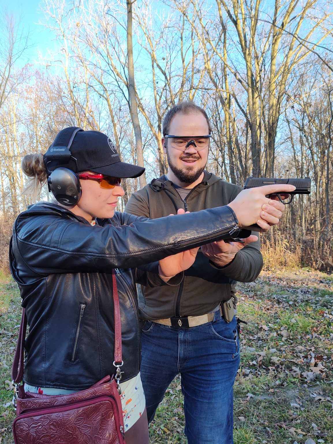 Watchman Defense instructor coaching a student on her grip and stance at the range